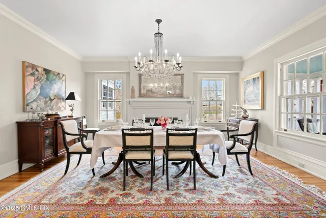 a view of a dining room with furniture a rug and wooden floor