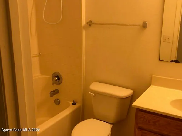 a white toilet sitting next to a bath tub