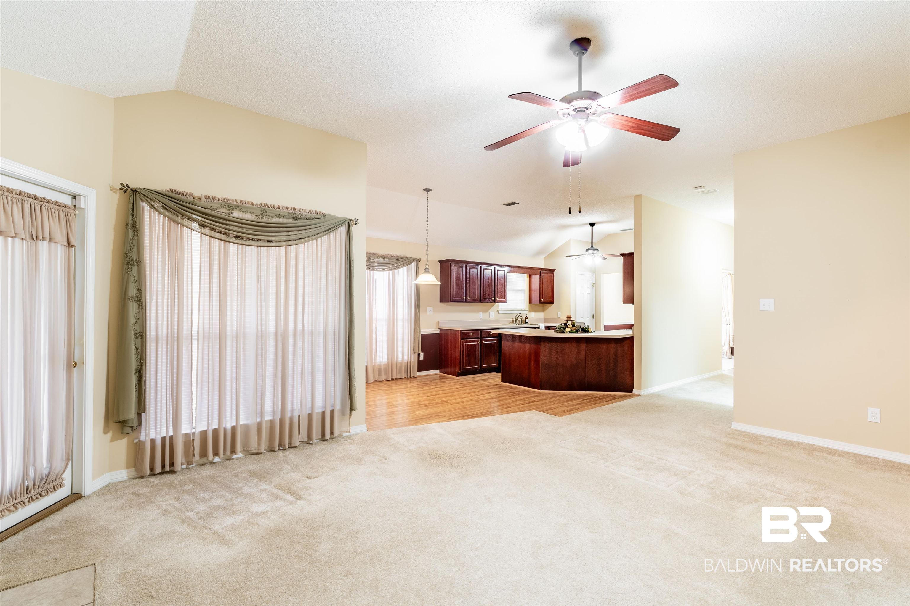 1784 Harrington Way Mobile, AL 36695 - Photo 3 of 18 Carpeted living room featuring lofted ceiling and ceiling fan