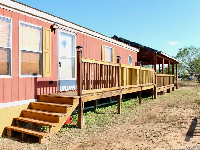a view of a house with a wooden deck