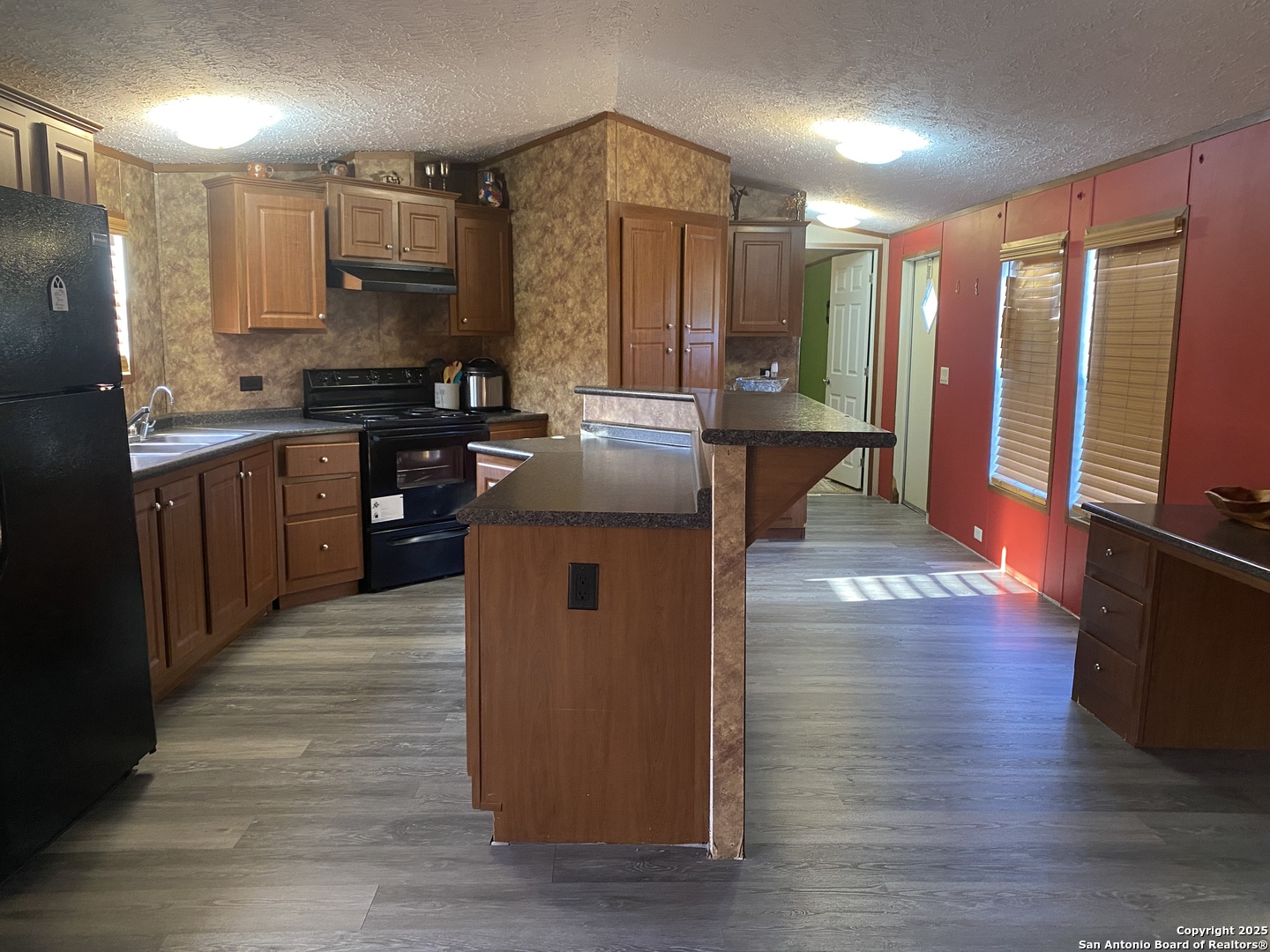 13014 Bernhardt Road San Antonio, TX 78263 - Photo 10 of 29 a kitchen with kitchen island granite countertop wooden floors and a sink