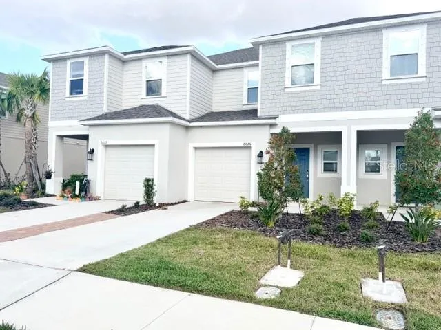 a front view of a house with a yard and garage