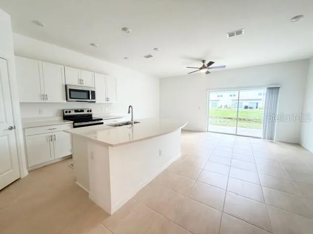 a kitchen with a stove a sink and a microwave