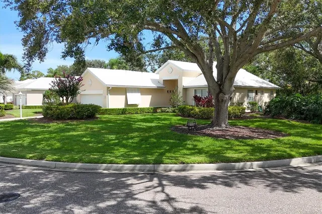 a front view of a house with a yard and trees