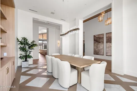 a living room with large windows and a potted plant