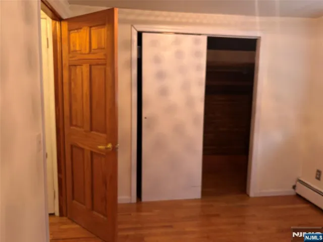an empty room with wooden floor and closet