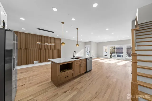 a large kitchen with stainless steel appliances a large counter top a stove and a refrigerator