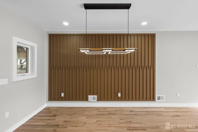 an empty room with wooden floor and window