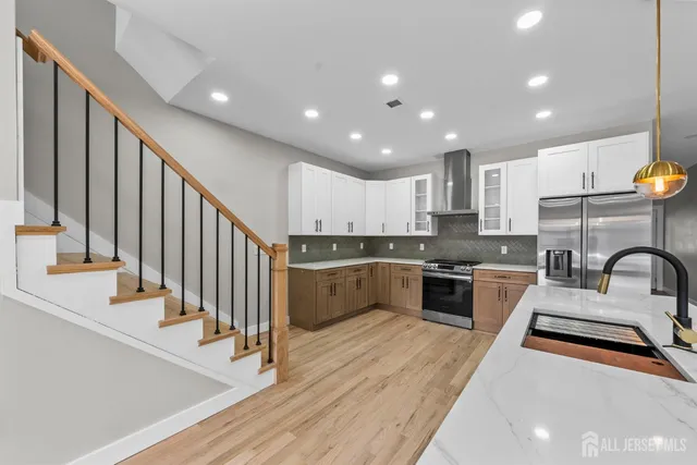 a kitchen with stainless steel appliances sink a stove and cabinets