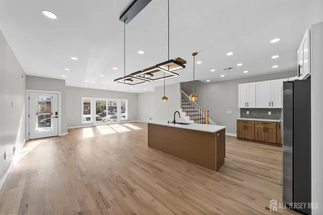 a large kitchen with stainless steel appliances kitchen island a large counter top and a wooden floors