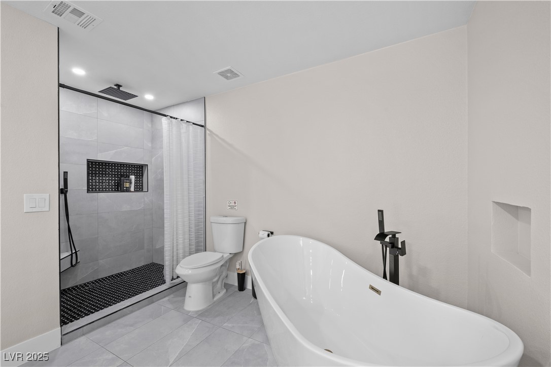 3482 Pueblo Way Las Vegas, NV 89169 - Photo 19 of 55 Luxurious primary bath features a spacious layout with a soaking tub and a sleek, separate shower for ultimate relaxation.