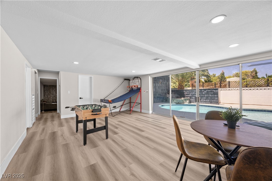 3482 Pueblo Way Las Vegas, NV 89169 - Photo 33 of 55 Designed for connection and comfort, this vibrant gaming space features full furnishings, plenty of light, and easy flow to the backyard with pool.