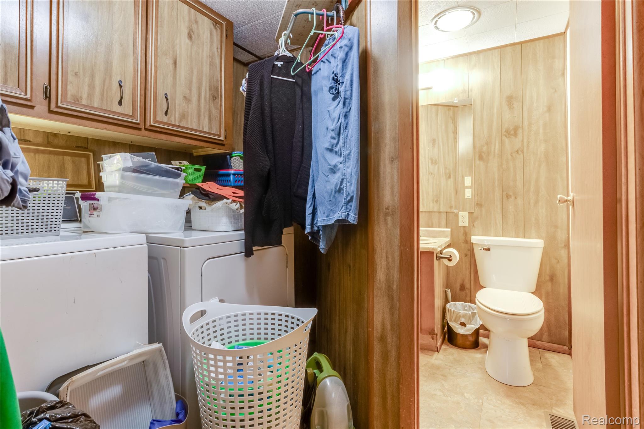 3333 Ravenswood Road Marysville, MI 48040 - Photo 20 of 25 Laundry area with wooden walls, cabinet space, and independent washer and dryer
