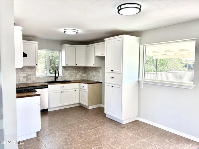 a kitchen with granite countertop white cabinets and white appliances