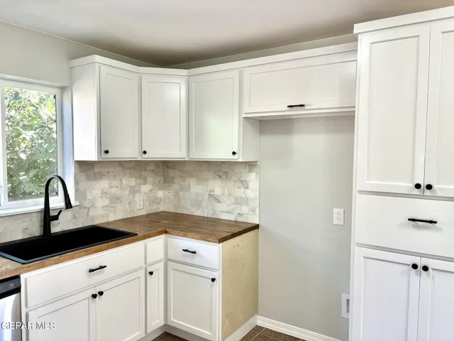 a kitchen with white cabinets and a sink