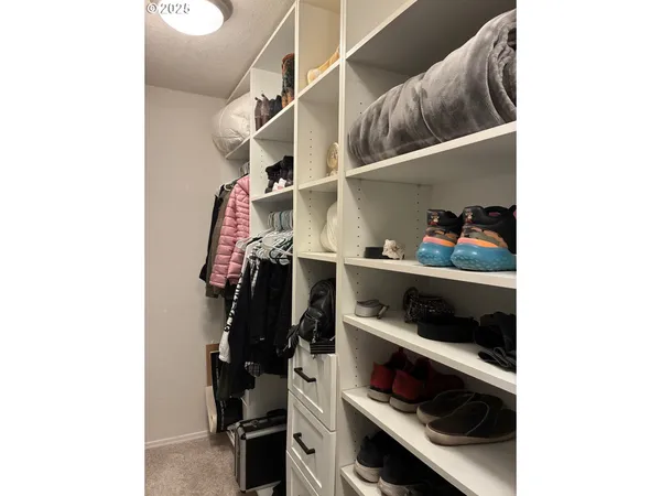 a view of walk in closet with clothes and shoes