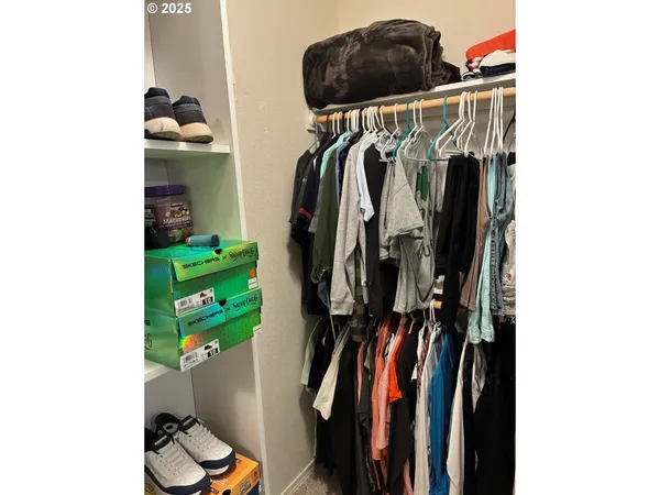 a view of walk in closet with clothes and shoes