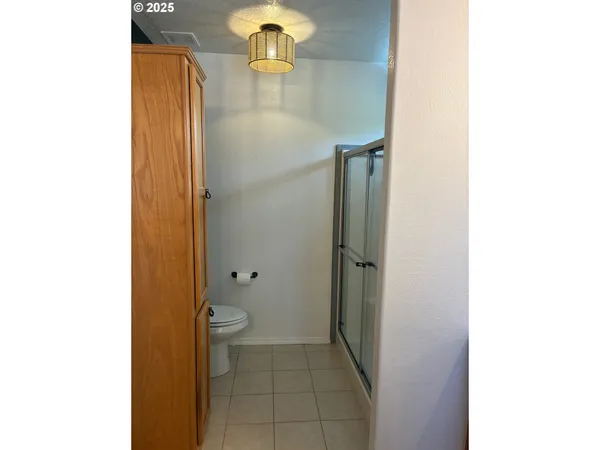 a bathroom with a granite countertop shower and a toilet
