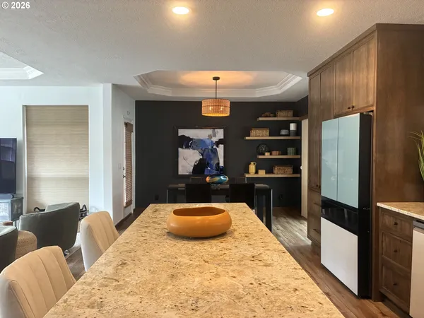 a kitchen with stainless steel appliances kitchen island granite countertop a refrigerator and a sink