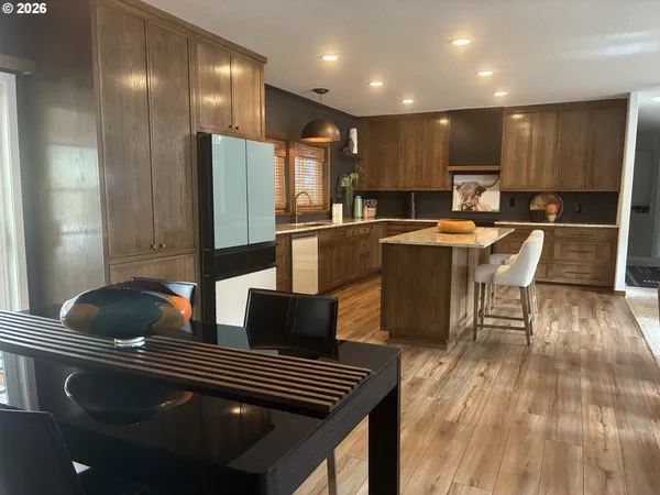 a kitchen with stainless steel appliances granite countertop a sink and a refrigerator