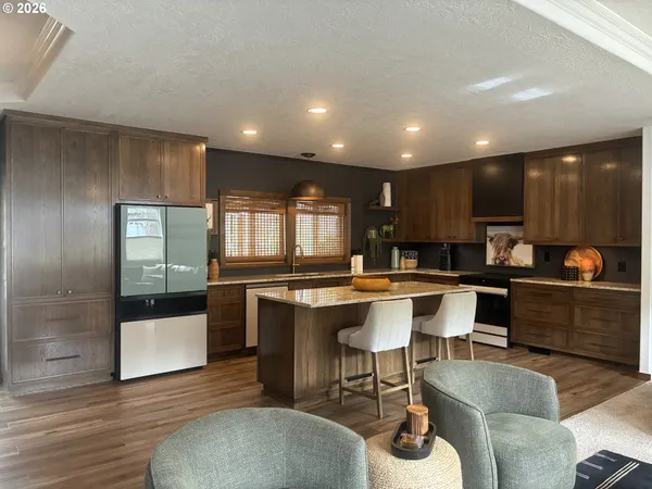 a kitchen with counter and chairs in it
