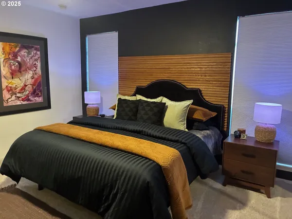 a bedroom with a bed and a painting on the wall