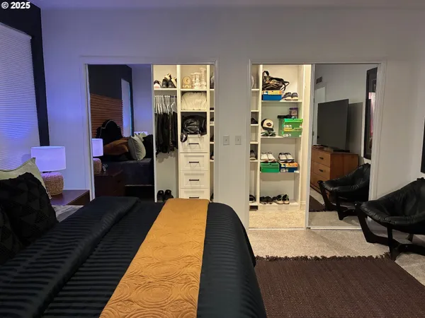 a bedroom with bed and a flat tv screen on dresser