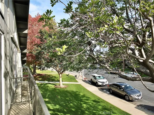 a front view of a house with garden and trees