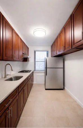 a kitchen with stainless steel appliances granite countertop wooden cabinets a sink and a refrigerator