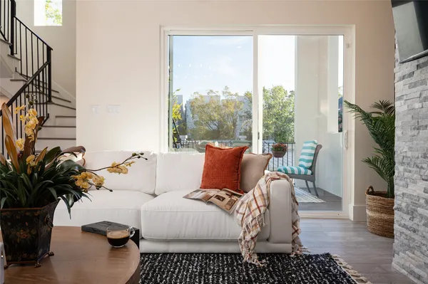 a living room with furniture floor to ceiling window and a potted plant