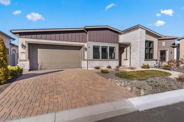 a front view of a house with a yard outdoor seating and garage