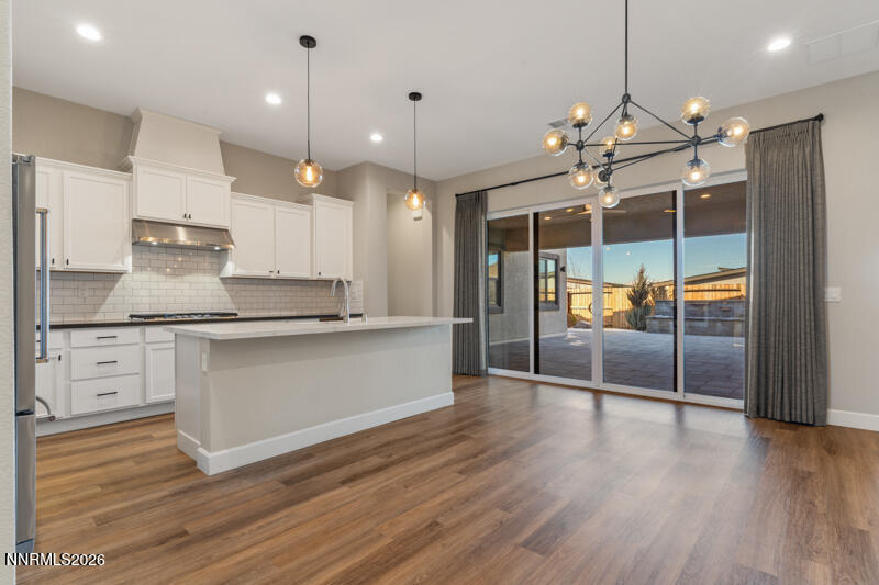 2221 Paint Horse Drive Reno, NV 89521 - Photo 21 of 53 a large kitchen with granite countertop a stove a sink and white cabinets with wooden floor