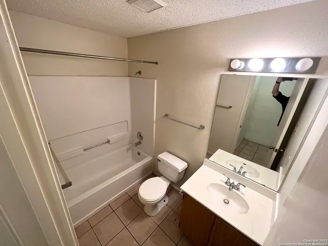 a bathroom with a sink mirror vanity and toilet