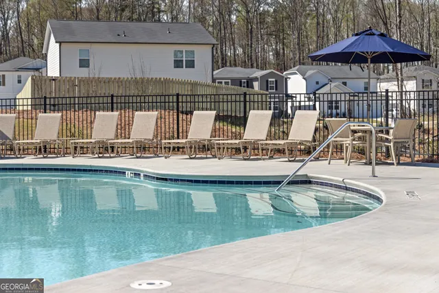 a view of a house with a bath tub and couches next to red umbrella
