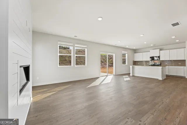 a white kitchen with wooden floor and black white cabinets