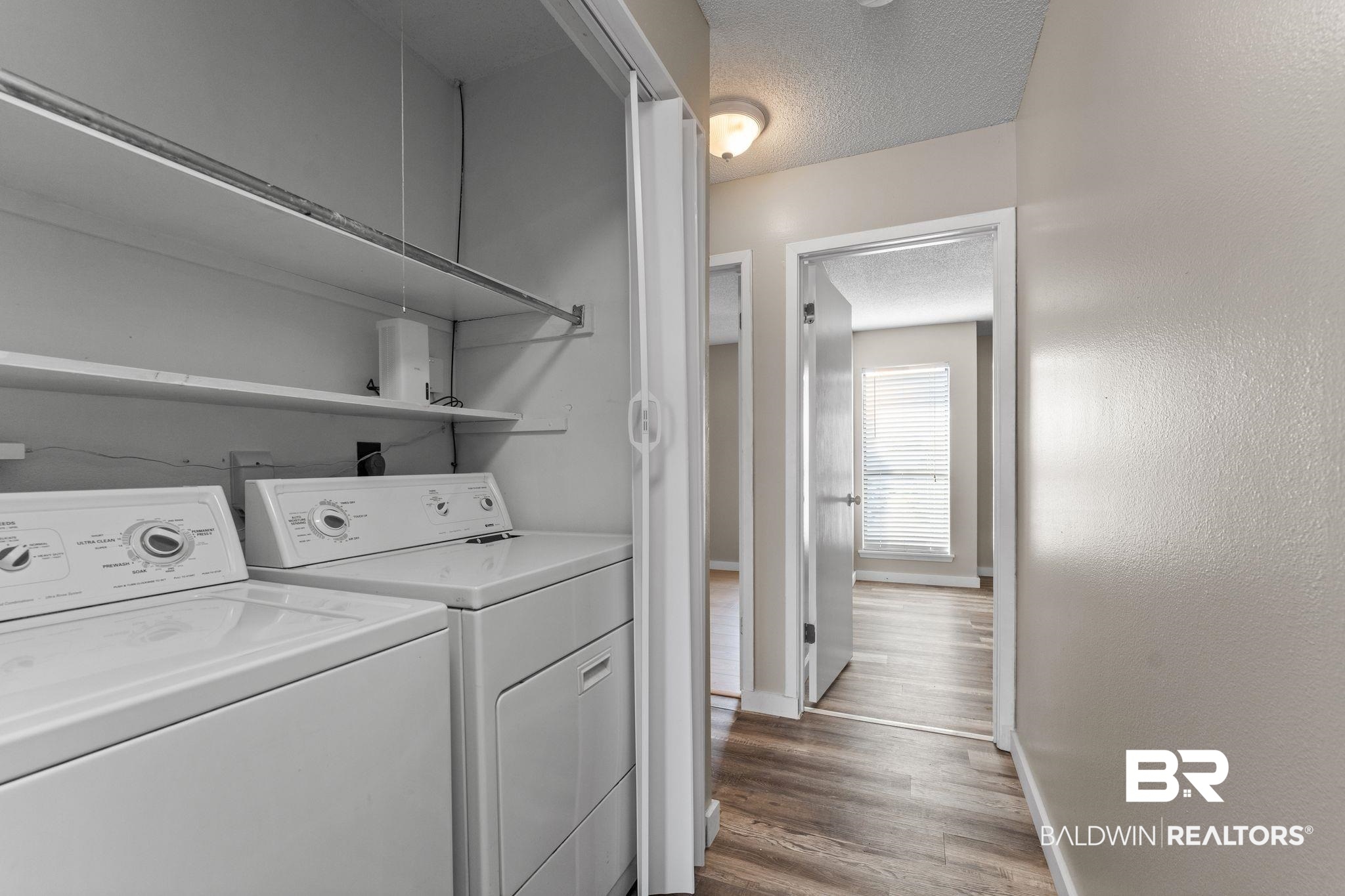 128 West Satsuma Avenue, Unit 128 Foley, AL 36535 - Photo 26 of 41 Laundry room featuring a textured ceiling, washer and clothes dryer, and dark wood finished floors