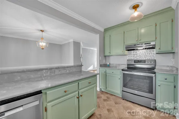 a kitchen with stainless steel appliances granite countertop a sink a stove and cabinets