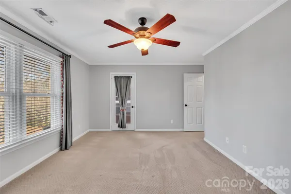 a view of an empty room with ceiling fan