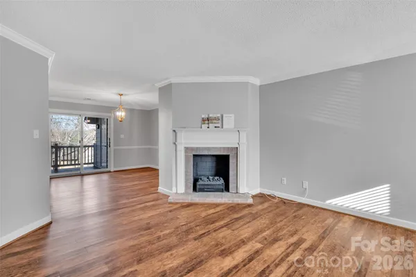 a view of a livingroom with wooden floor and a fireplace