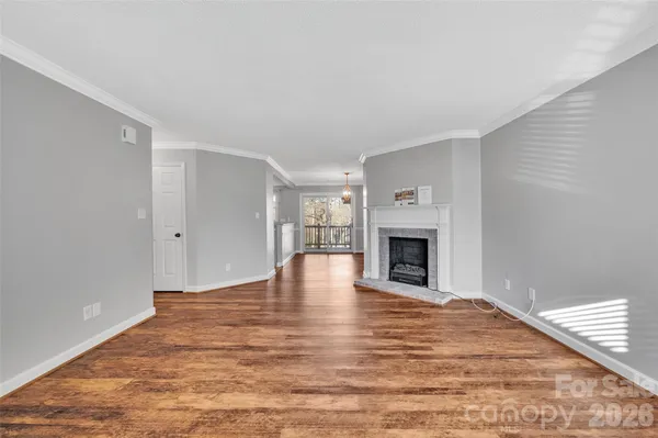 a view of empty room with wooden floor and fireplace
