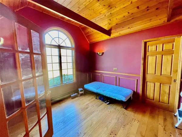 a bedroom with a bed dresser and a large window