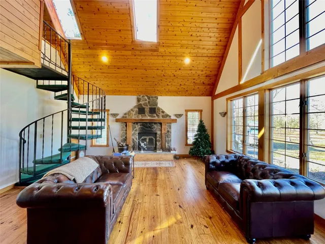 a living room with furniture fireplace and a large window