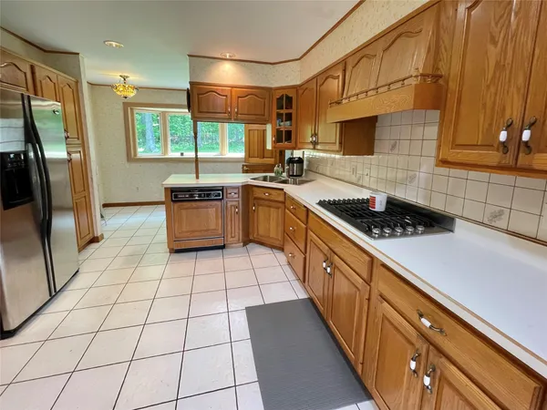 a kitchen with stainless steel appliances a sink a stove a refrigerator and cabinets