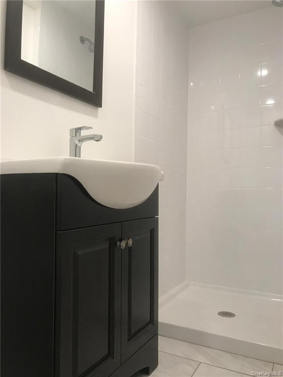 93 Main Street Garnerville, NY 10923 - Photo 11 of 15 a bathroom with a sink a mirror and a bathtub