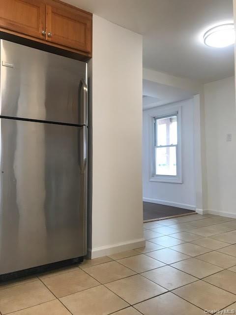 93 Main Street Garnerville, NY 10923 - Photo 6 of 15 a view of a refrigerator in kitchen and an empty room with wooden floor