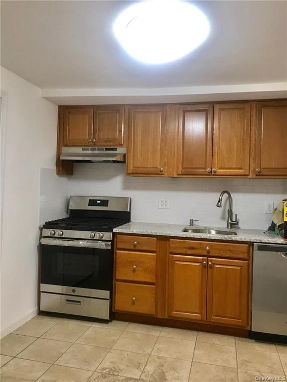 93 Main Street Garnerville, NY 10923 - Photo 7 of 15 a kitchen with stainless steel appliances granite countertop a stove a sink and a microwave