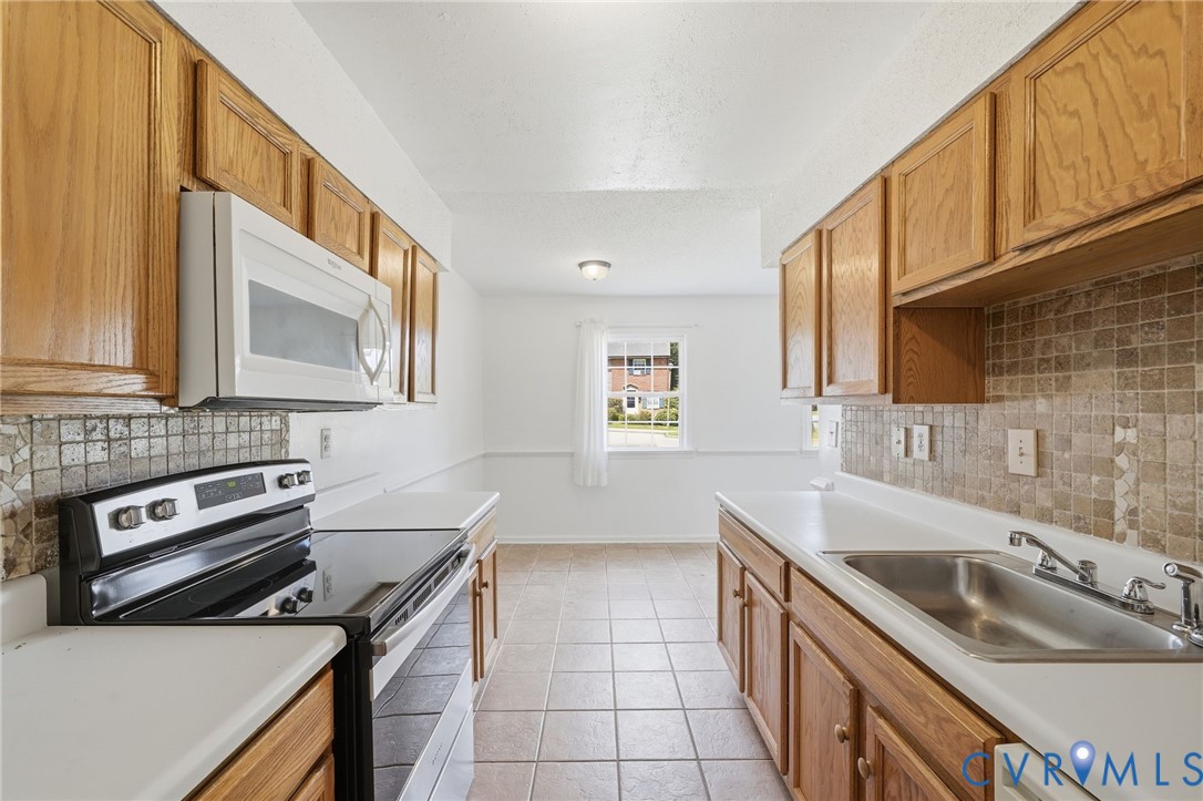 1501 Ivymount Road Richmond, VA 23225 - Photo 3 of 31 Galley kitchen featuring wood cabinetry, white cou