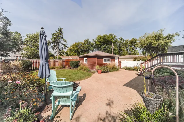 a front view of a house with a yard and potted plants