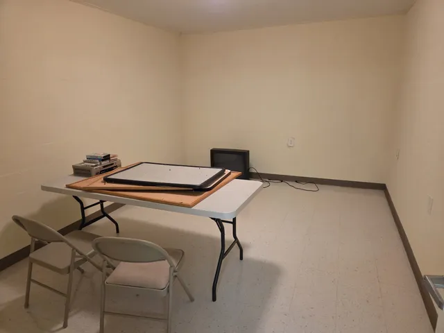 a view of a workspace with furniture and a window