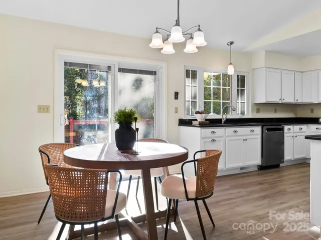 a view of a dining room with furniture wooden floor and chandelier